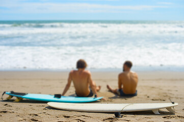 Image showing Surfers rest on the beach