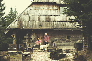 Image showing frineds together in front of old wooden house