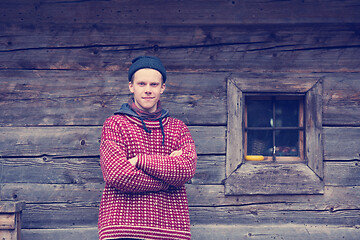 Image showing young hipster in front of wooden house