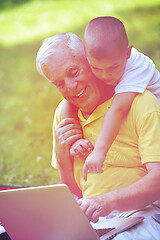 Image showing grandfather and child using laptop