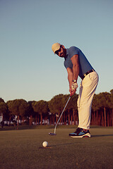 Image showing golfer  hitting shot at golf course