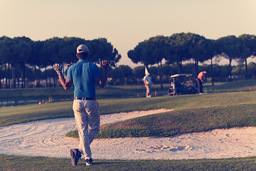 Image showing golfer from back at course looking to hole in distance