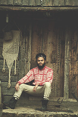 Image showing portrait of young hipster in front of wooden house