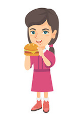 Image showing Little caucasian girl eating a hamburger.