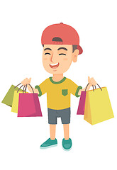 Image showing Happy caucasian boy holding shopping bags.