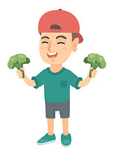 Image showing Little caucasian boy laughing and holding broccoli