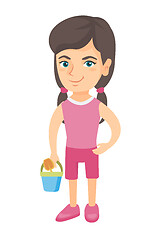 Image showing Caucasian girl in shorts holding pail and shovel.