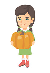 Image showing Caucasian girl standing with a big orange pumpkin.