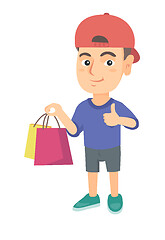 Image showing Happy caucasian boy holding shopping bags.