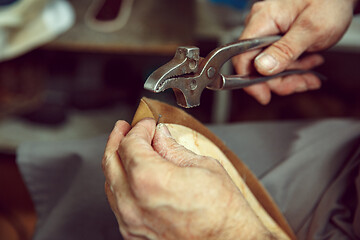 Image showing Enjoying process of creation custom made shoes. Workplace of shoe designer