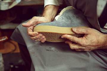 Image showing Enjoying process of creation custom made shoes. Workplace of shoe designer