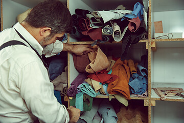 Image showing Tailor man working in his tailor shop, Tailoring, close up