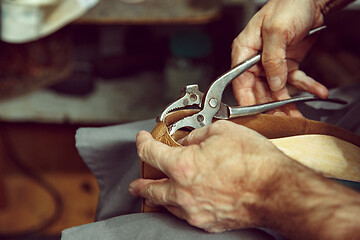 Image showing Enjoying process of creation custom made shoes. Workplace of shoe designer