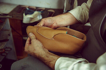 Image showing Enjoying process of creation custom made shoes. Workplace of shoe designer