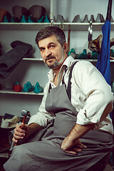 Image showing Enjoying process of creation custom made shoes. Workplace of shoe designer