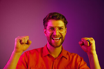 Image showing The happy business man standing and smiling against pink background.