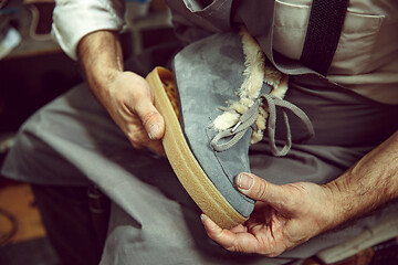 Image showing Enjoying process of creation custom made shoes. Workplace of shoe designer