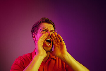 Image showing Isolated on pink young casual man shouting at studio