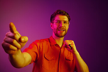 Image showing The happy business man standing and smiling against pink background.