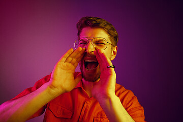 Image showing Isolated on pink young casual man shouting at studio