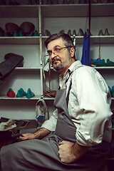 Image showing Enjoying process of creation custom made shoes. Workplace of shoe designer