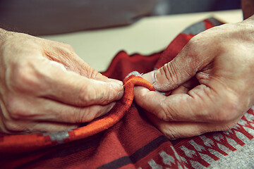 Image showing Tailor man working in his tailor shop, Tailoring, close up