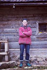 Image showing young hipster in front of wooden house