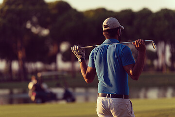 Image showing golfer from back at course looking to hole in distance