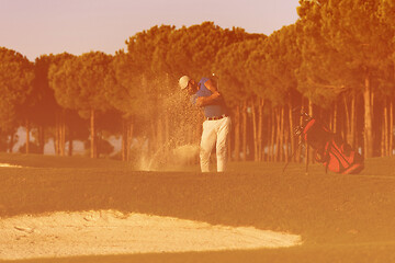 Image showing golfer hitting a sand bunker shot on sunset