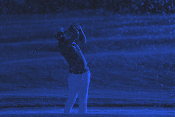 Image showing golfer hitting a sand bunker shot on sunset