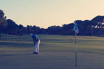 Image showing golfer hitting ball to hole