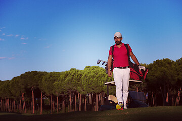 Image showing golfer  walking and carrying golf  bag