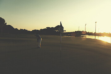 Image showing golfer hitting ball to hole