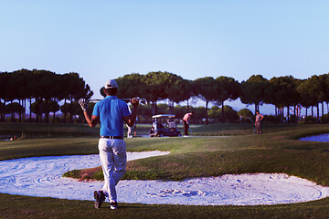 Image showing golfer from back at course looking to hole in distance