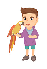 Image showing Caucasian little boy holding parrot on his hand.