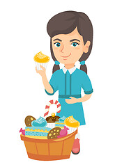 Image showing Girl holding a cupcake and stroking her belly.
