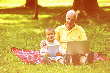 Image showing grandfather and child in park using tablet