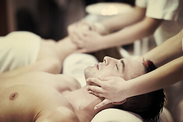 Image showing relaxed young couple getting massage in spa