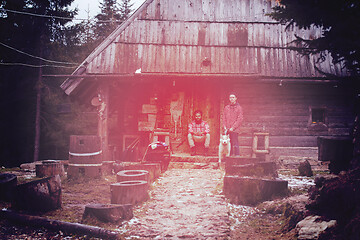 Image showing frineds together in front of old wooden house