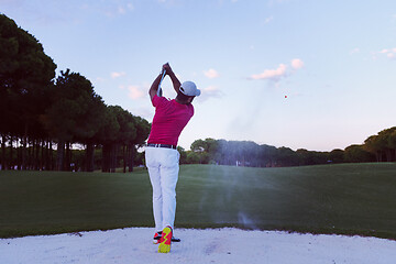 Image showing golfer hitting a sand bunker shot on sunset