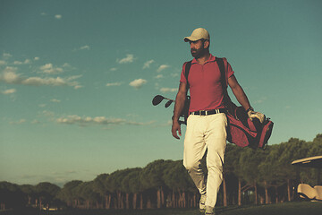 Image showing golfer  walking and carrying golf  bag