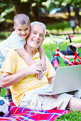 Image showing grandfather and child using laptop