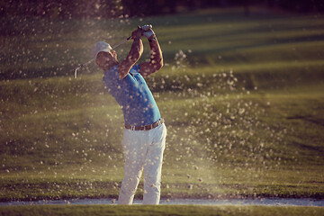 Image showing golfer hitting a sand bunker shot on sunset