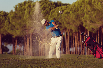 Image showing golfer hitting a sand bunker shot on sunset