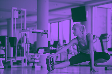 Image showing woman stretching and warming up for her training at a gym