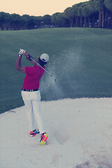 Image showing golfer hitting a sand bunker shot on sunset