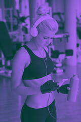 Image showing woman with headphones in fitness gym