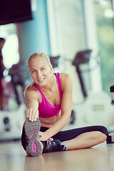 Image showing woman stretching and warming up for her training at a gym