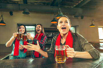 Image showing Sport, people, leisure, friendship and entertainment concept - happy football fans or female friends drinking beer and celebrating victory at bar or pub