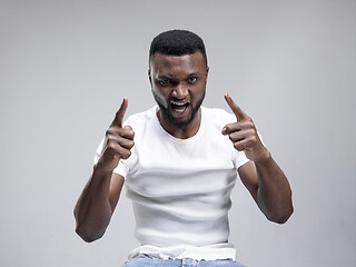 Image showing The young emotional angry man screaming on gray studio background